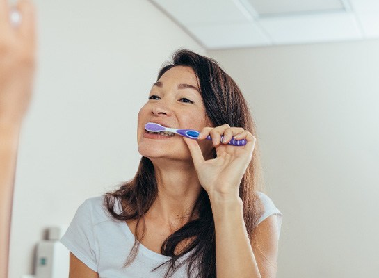 Woman brushing her teeth in bathroom