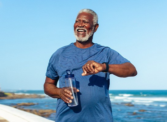 Senior man smiling while walking on beach path