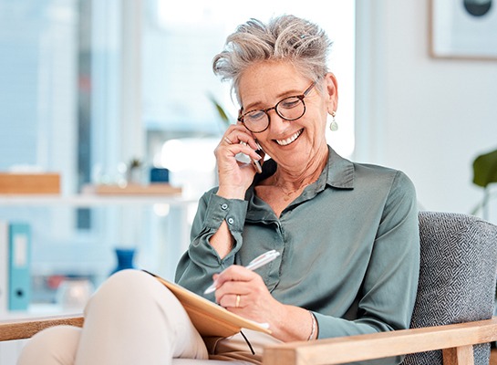 Woman smiling while talking on phone at home