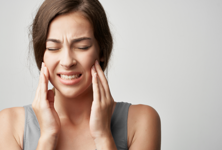 Woman holding jaw in pain