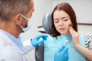 a patient sits in dental exam chair while a emergency dentist in hanover md examines her teeth
